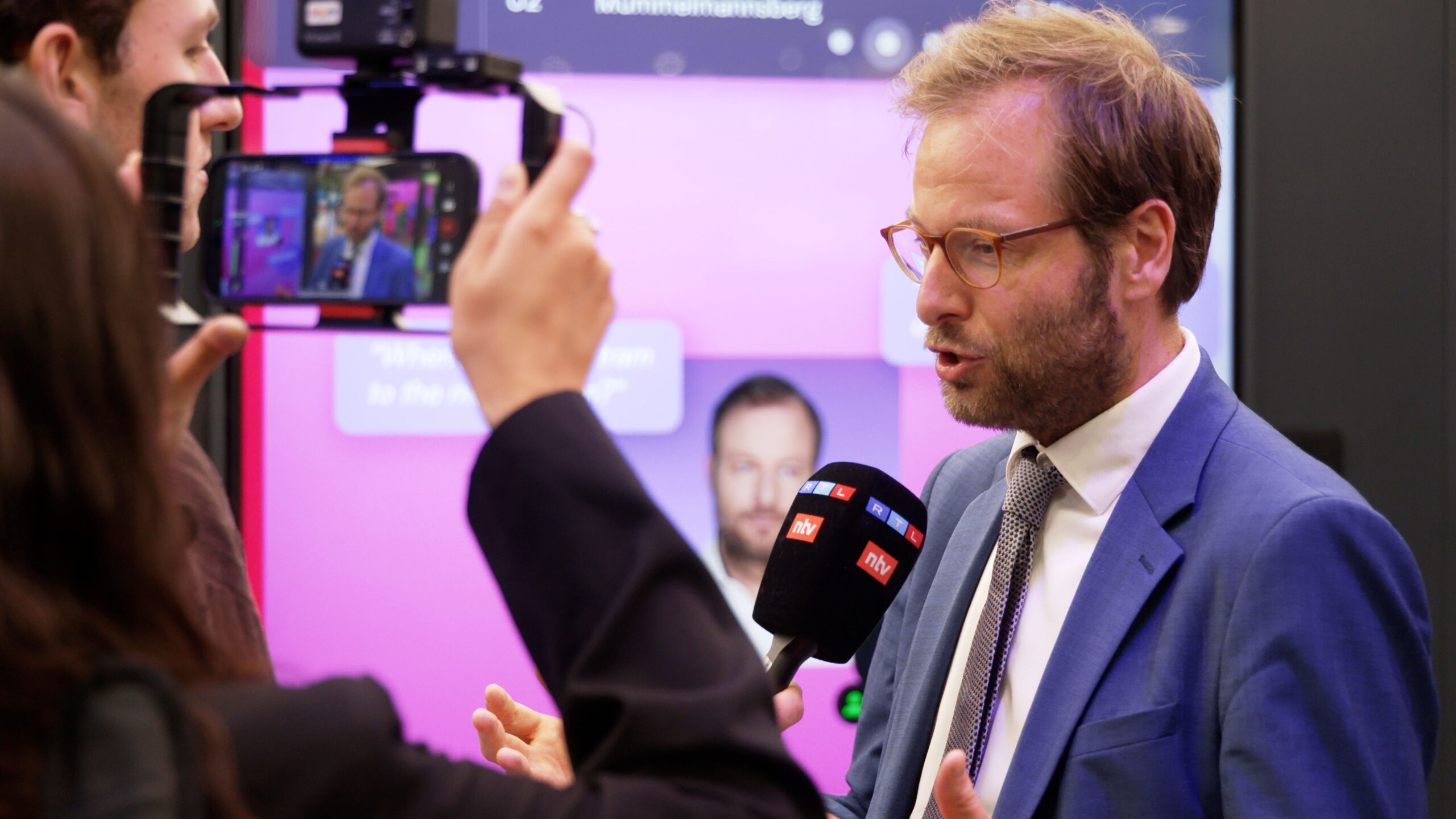Anjes Tjarks Interviewed Beside His AI Avatar at UITP 2025 – HVV “The Next Stop” Anjes Tjarks being interviewed by RTL and ntv in front of his AI-generated avatar at HVV’s UITP 2025 booth.